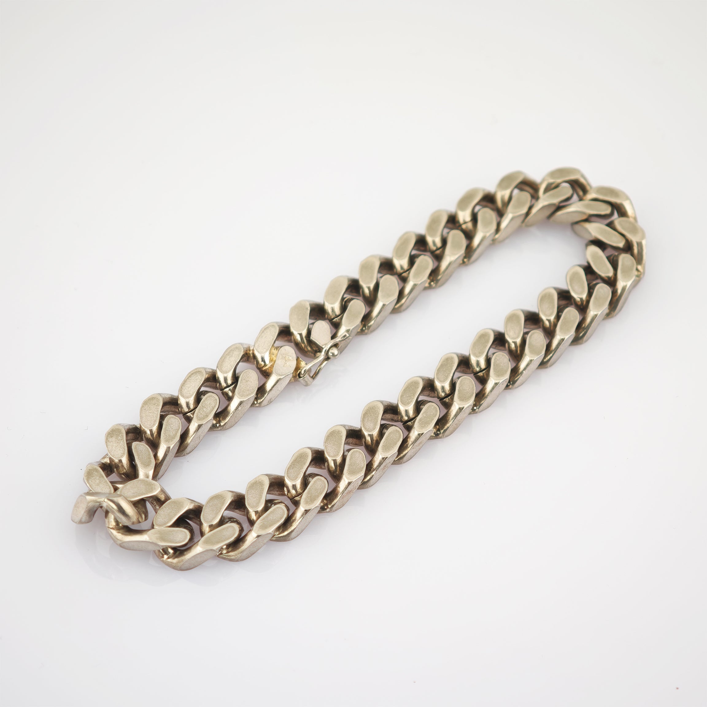 Massives Silberarmband mit poliertem Finish und ovalen Gliedern auf weißem Hintergrund.