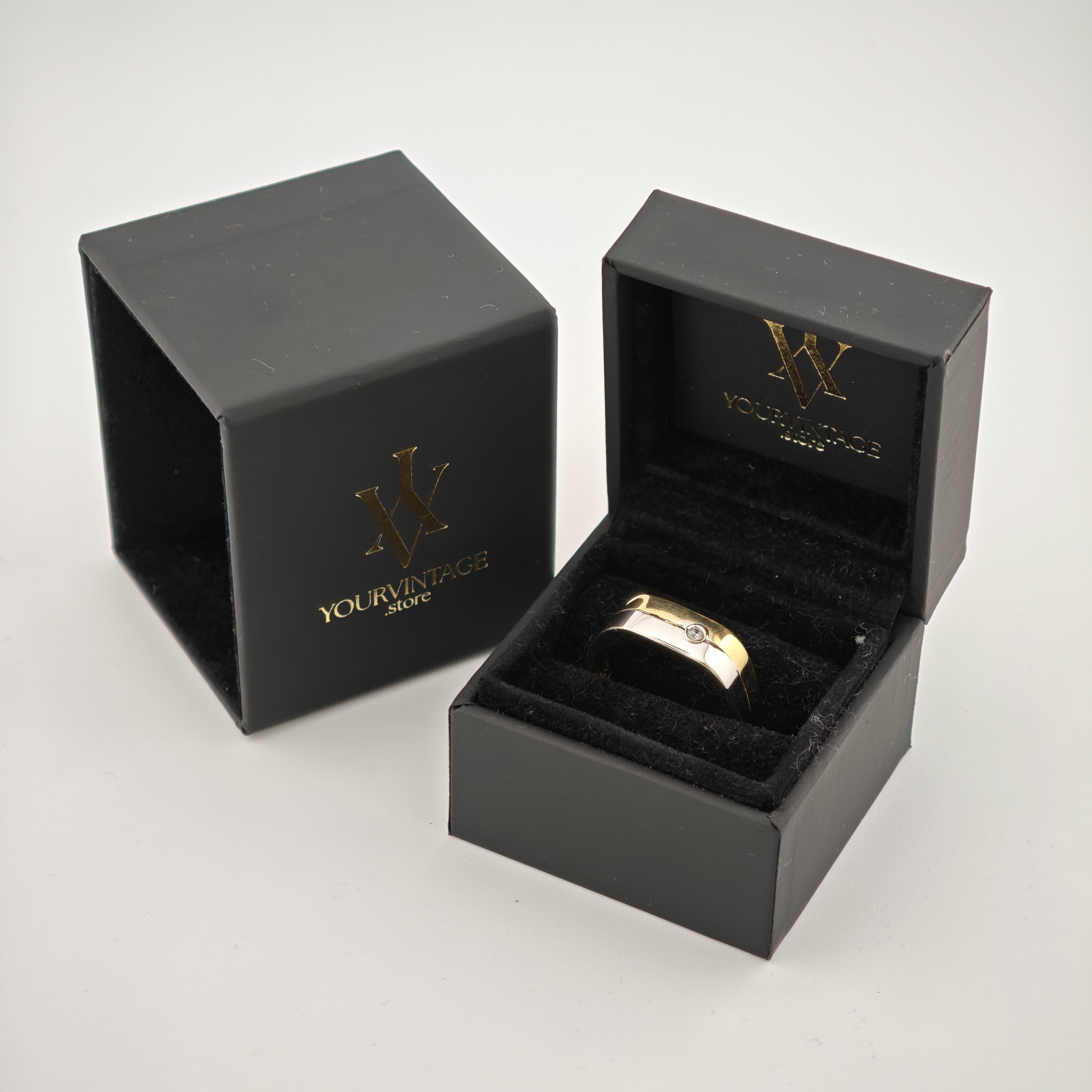 Matt-schwarze Schmuckschachtel mit goldgeprägtem YOURVINTAGE.store-Logo und goldenem Ring mit kleinem Diamanten.