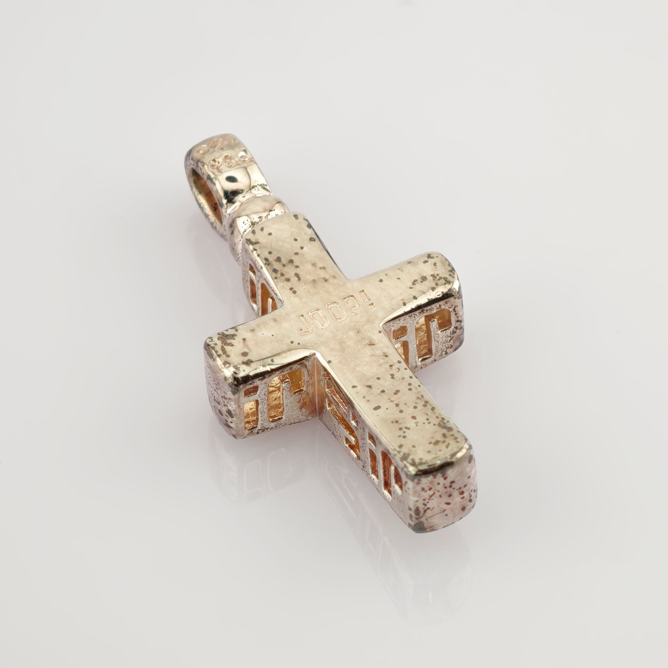 Metallkreuz-Anhänger mit angelaufener Oberfläche und JOOP! Gravur, dekorative Aussparungen an den Seiten.