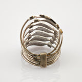 Metallring mit mehreren horizontalen Bändern und rechteckigem Verbindungsteil auf weißem Hintergrund