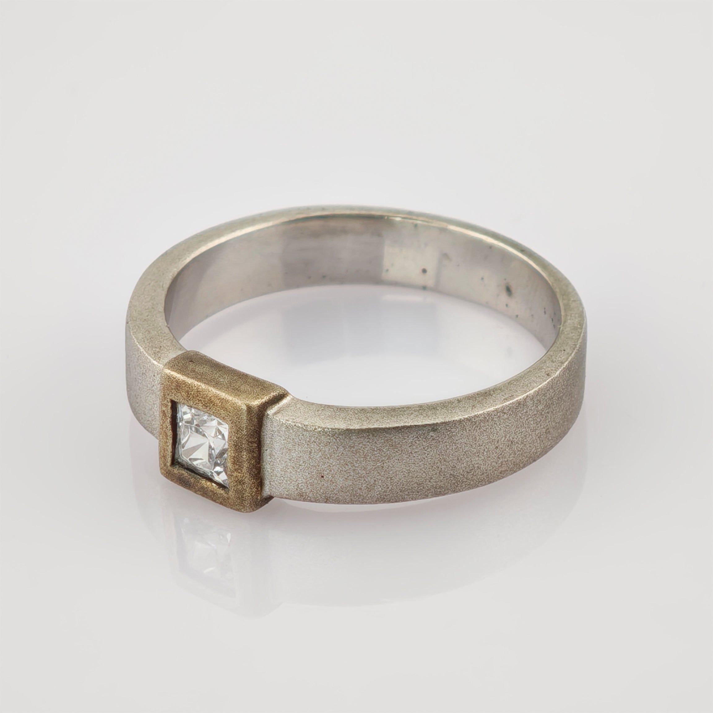 Moderner Silber- und Goldring mit quadratisch geschliffenem klarem Edelstein im goldenen Rand