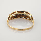 Nahaufnahme der Innenseite eines Goldrings mit offener Struktur und sichtbaren Metalltexturen.