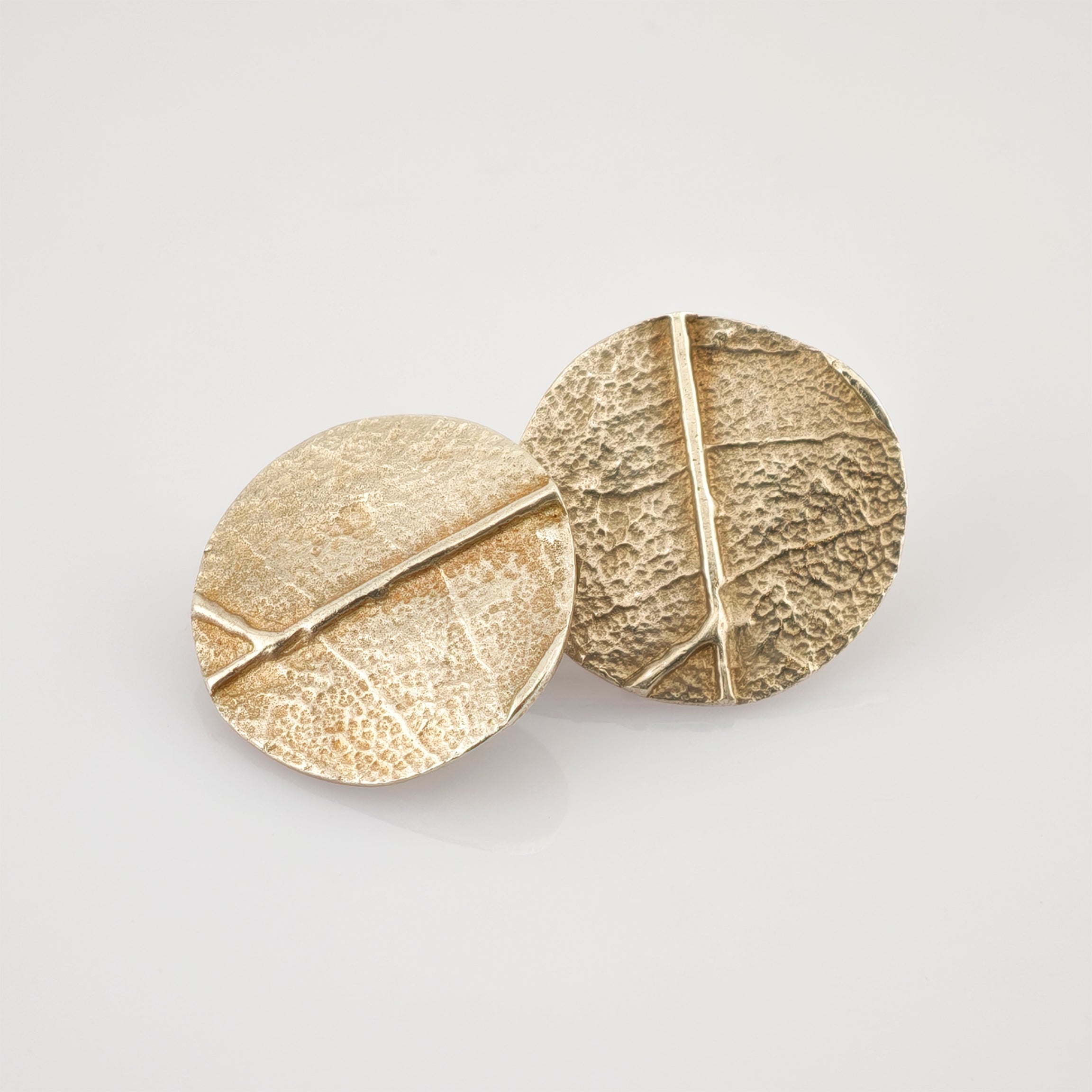 Vorderseite von zwei runden silbernen Ohrsteckers mit Steckverschluss und 925er Punze auf weißem Hintergrund