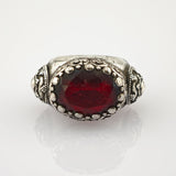 Ornater Silberring mit großem ovalem, tiefrotem Edelstein und filigranen Silberverzierungen.
