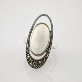 Ovaler Vintage-Ring mit poliertem weißen Stein in Silberfassung und filigranen Elementen