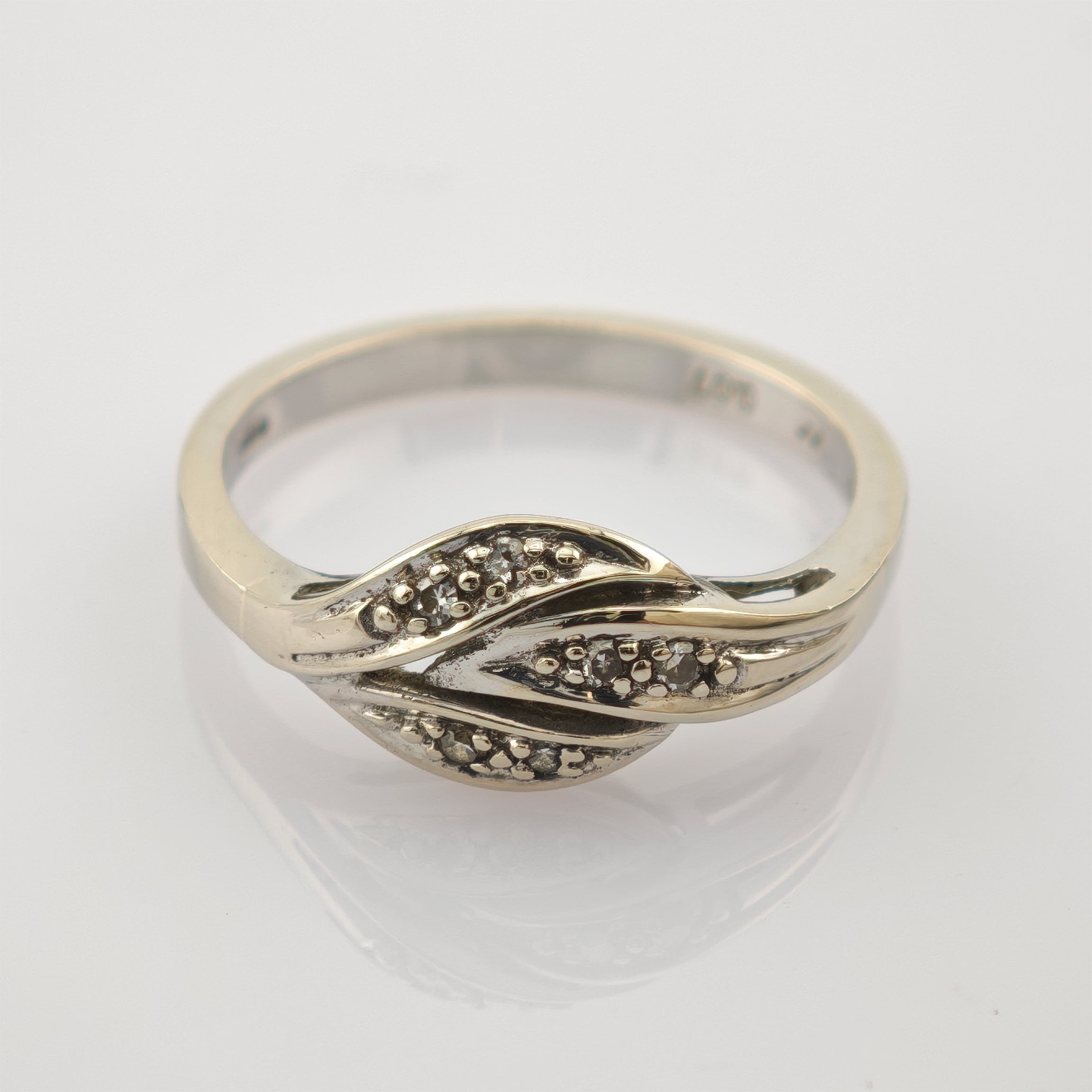 Polierter 14k-Goldring mit zwei ineinander verschlungenen Blattformen und kleinen Steinen.