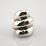 Polierter silberner Anhänger mit verdrehter Schleifenform auf weißem Untergrund.