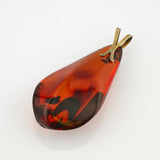 Polierter, tropfenförmiger Bernsteinanhänger in dunkelrotbraun mit Metallösen in Messing- oder Goldfarbe.