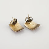 Paar quadratische, strukturierte Silberohrringe mit 925 Sterlingsilberpunze und Steckverschluss auf weißem Hintergrund.