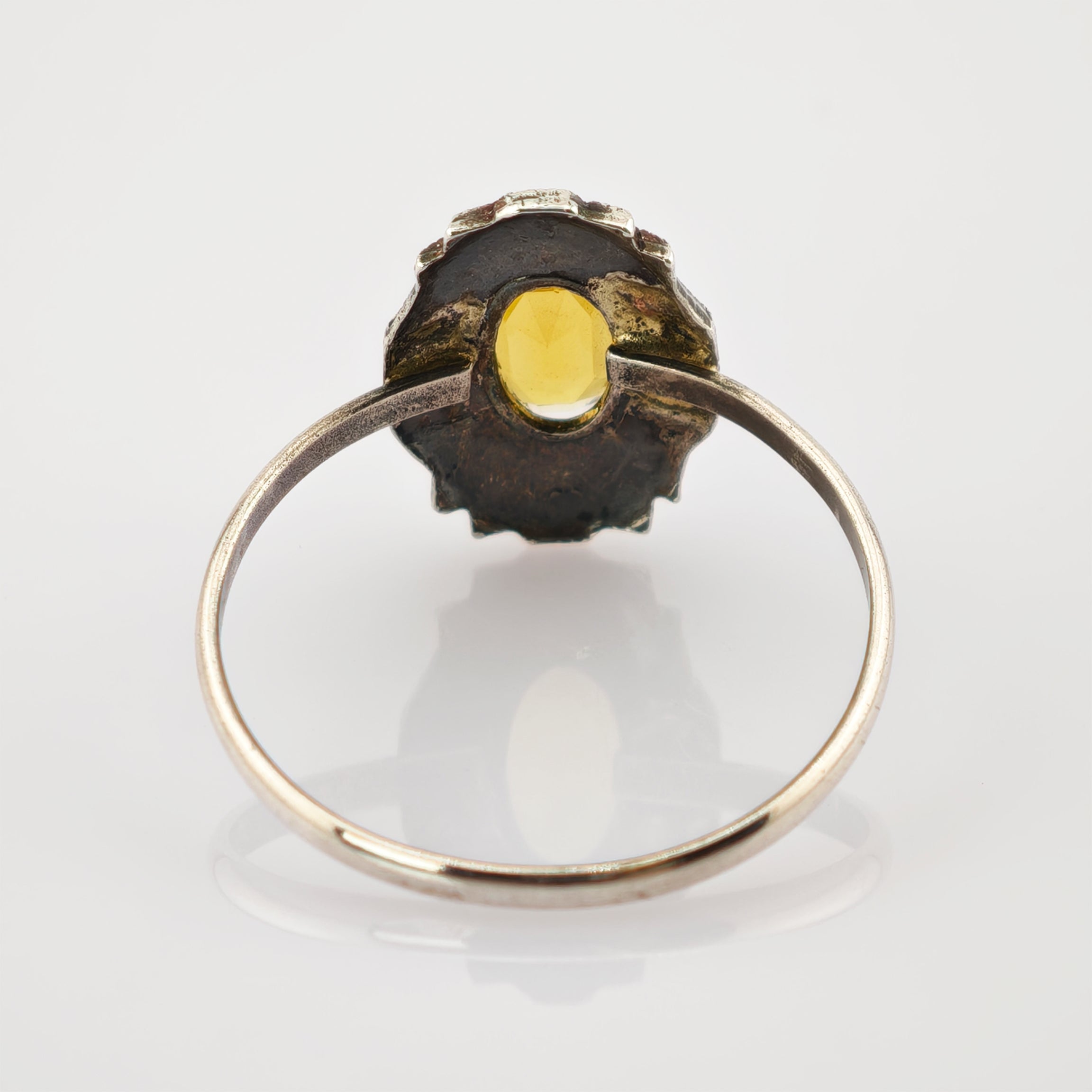 Eleganter Vintage-Silberring mit detaillierter Verzierung und ovalem gelben Edelstein.