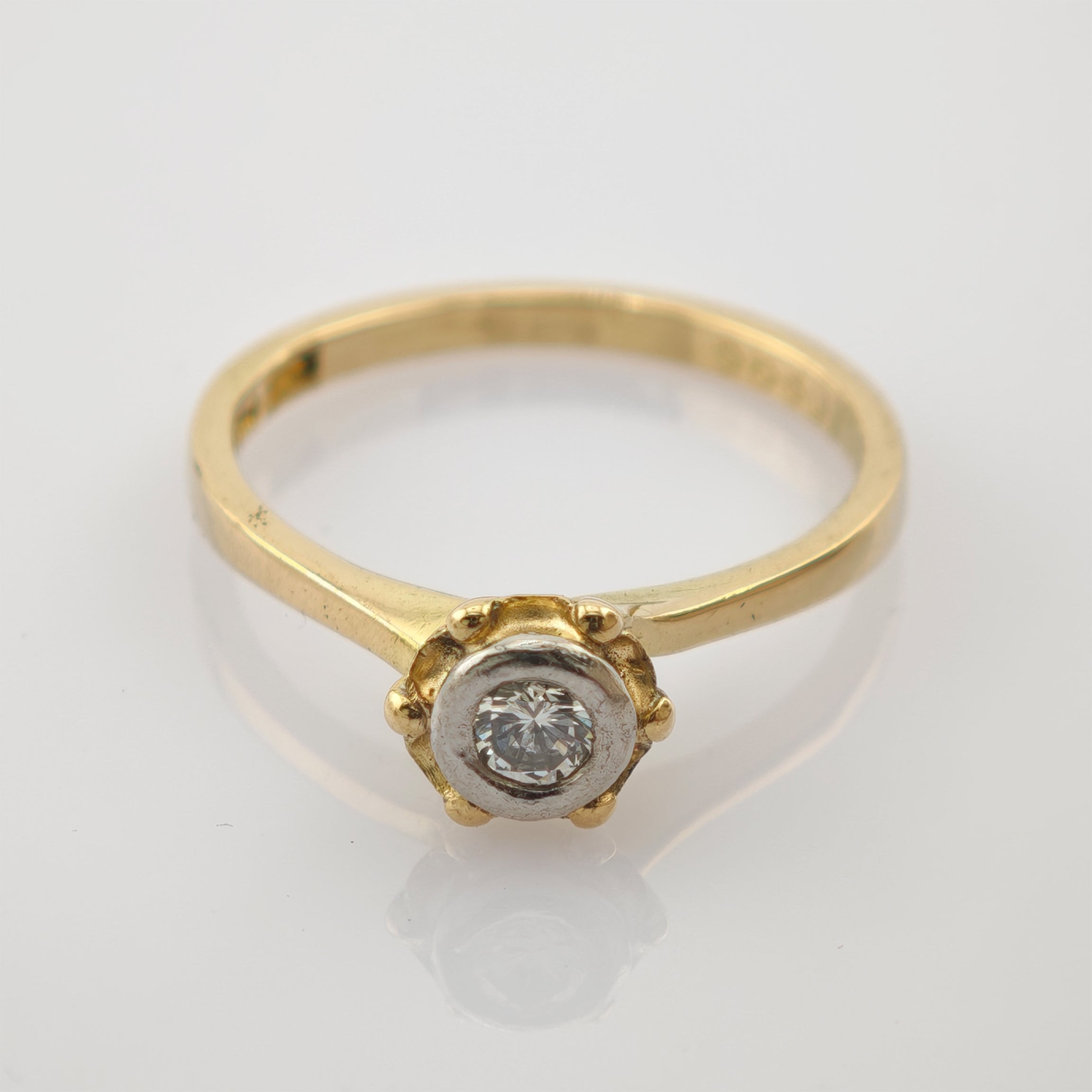 Schlanker Goldring mit rundem Diamant in zarter Weißmetallfassung und Goldperlendetails im Vintage-Stil