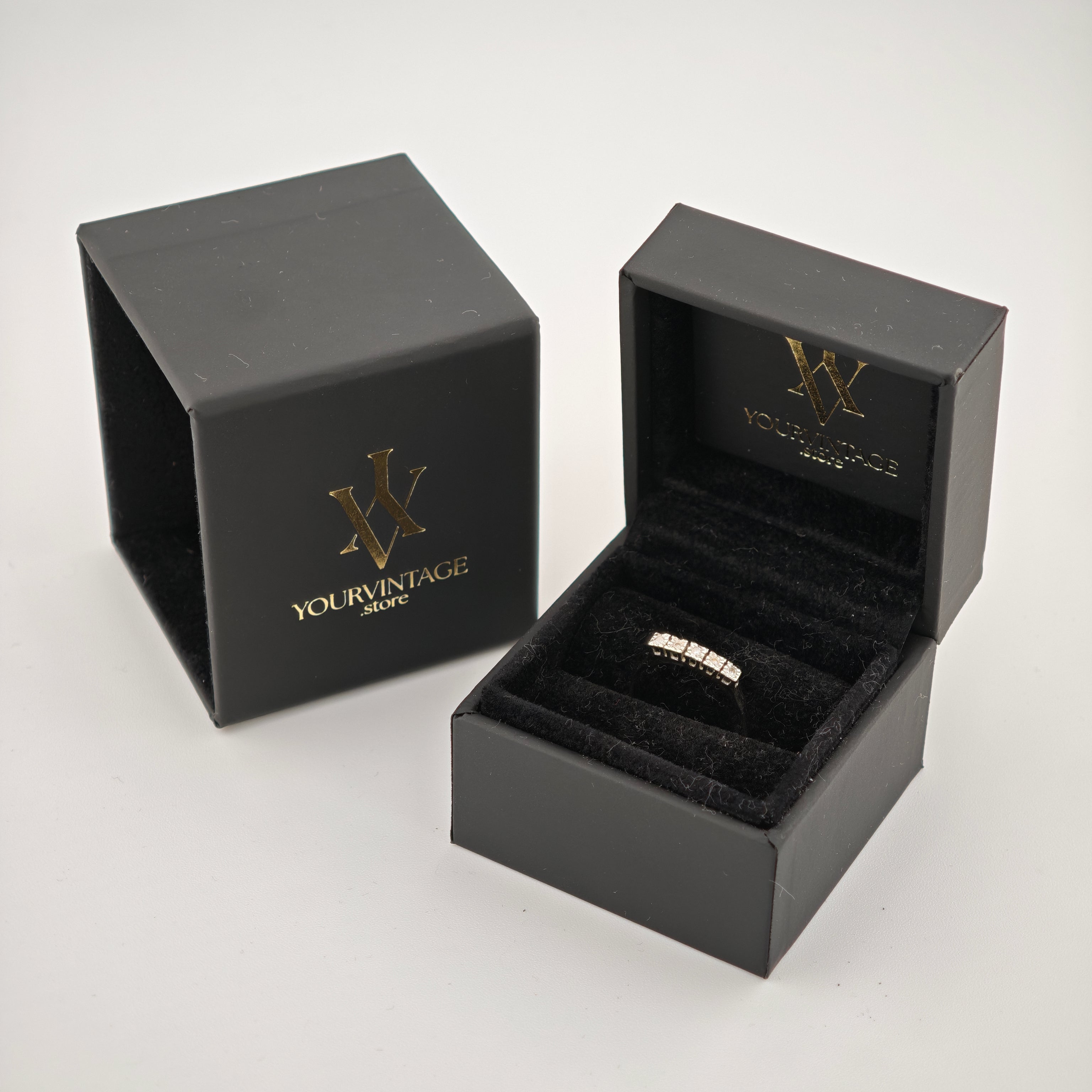 Schwarze Schmuckringbox mit silbernem Ring mit Diamanten, neben Deckel mit YourVintageStore-Logo.