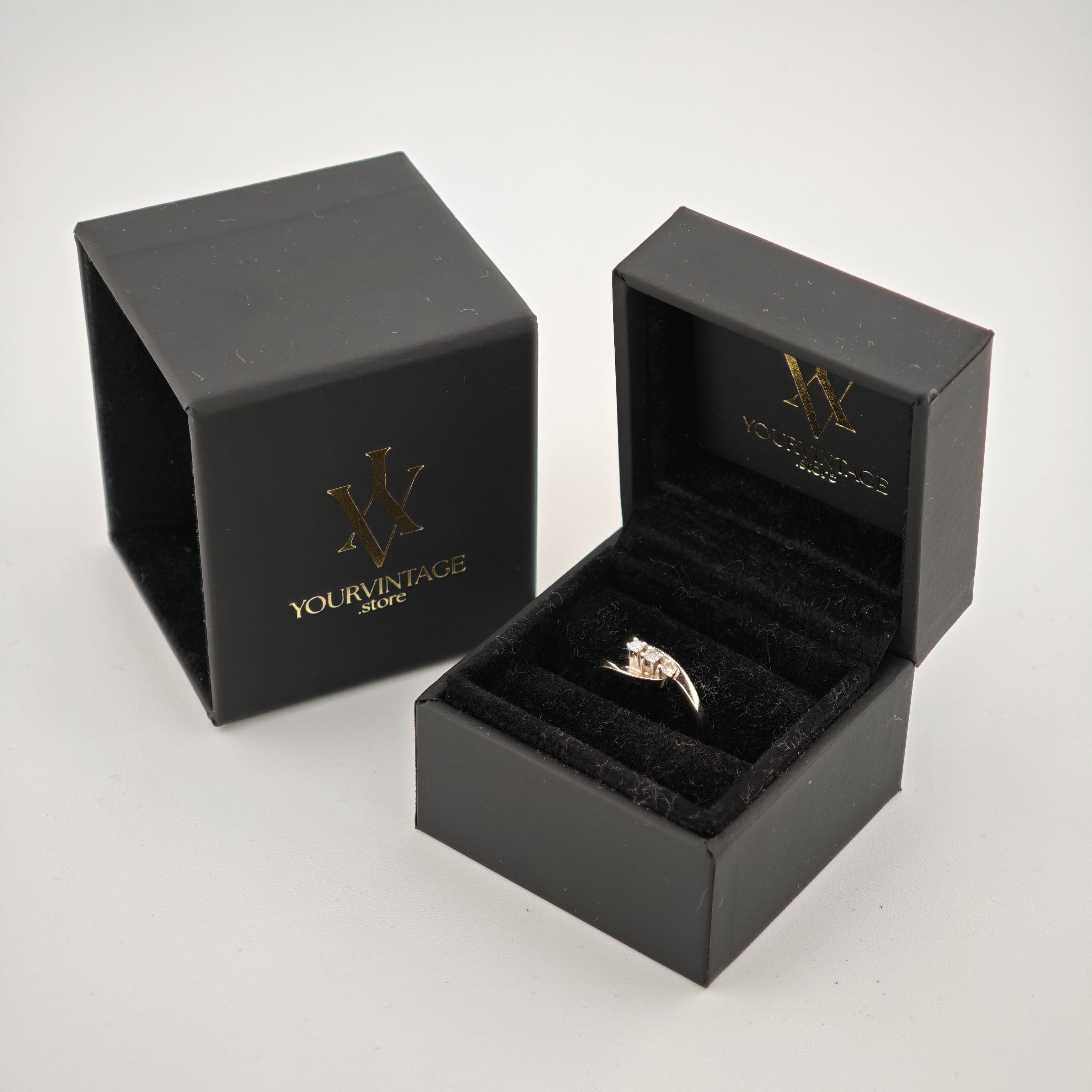 Schwarzes Schmuckkästchen mit samtigem Innenfutter, zeigt silbernen Ring und goldfarbenes Logo "W YOURVINTAGE.store"