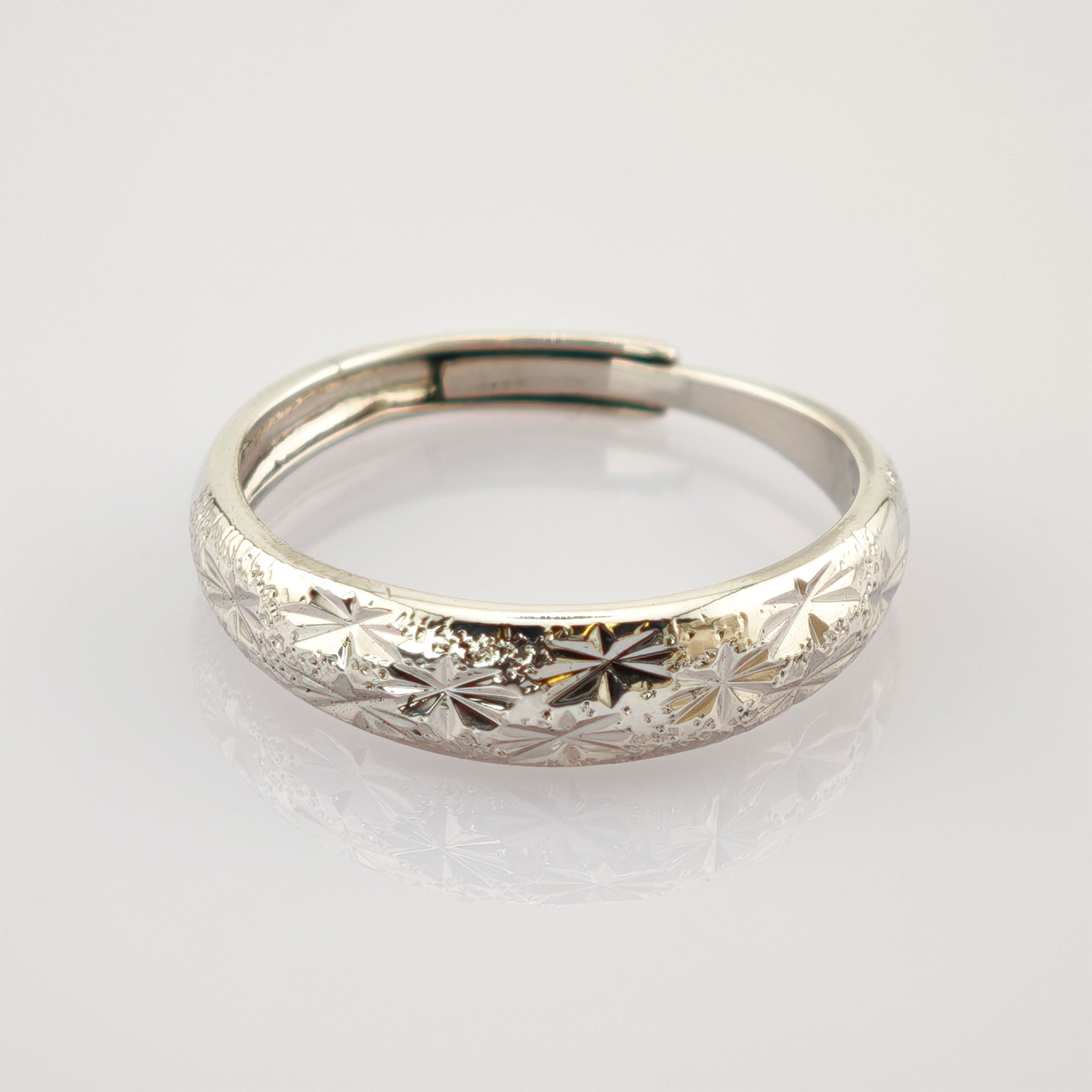 Silberarmband mit detailreichen sternförmigen Gravuren und glänzender Oberfläche.