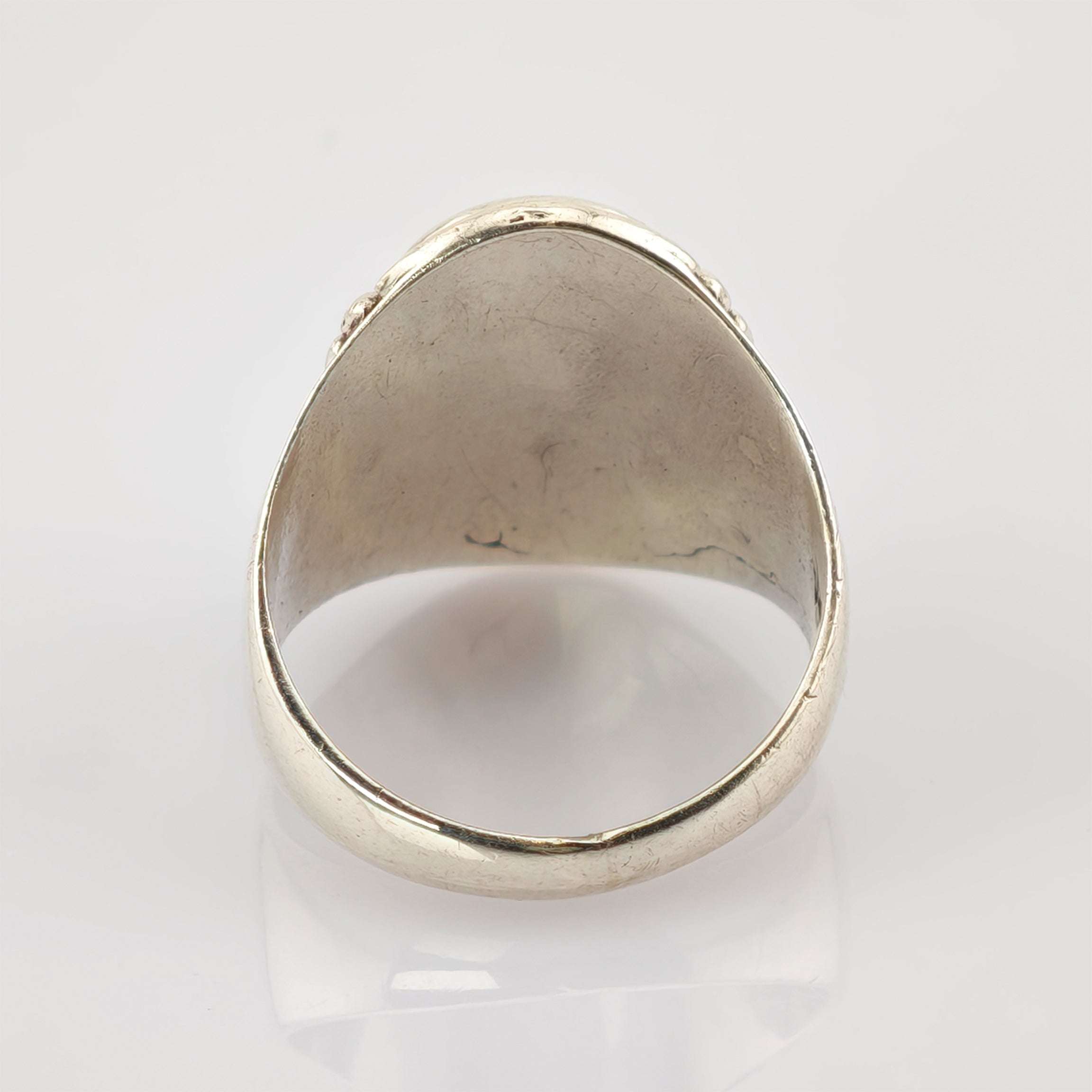 Silberfarbener Metallschmuckring mit sichtbaren Gebrauchsspuren und matter Oberfläche.