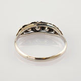 Silberfarbener Ring mit sichtbarer Innenseite und Fassung auf spiegelnder weißer Oberfläche