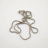 Silberne Boxkette mit rundem Verschluss und herzförmigem Anhänger mit Buchstabe B auf weißem Hintergrund