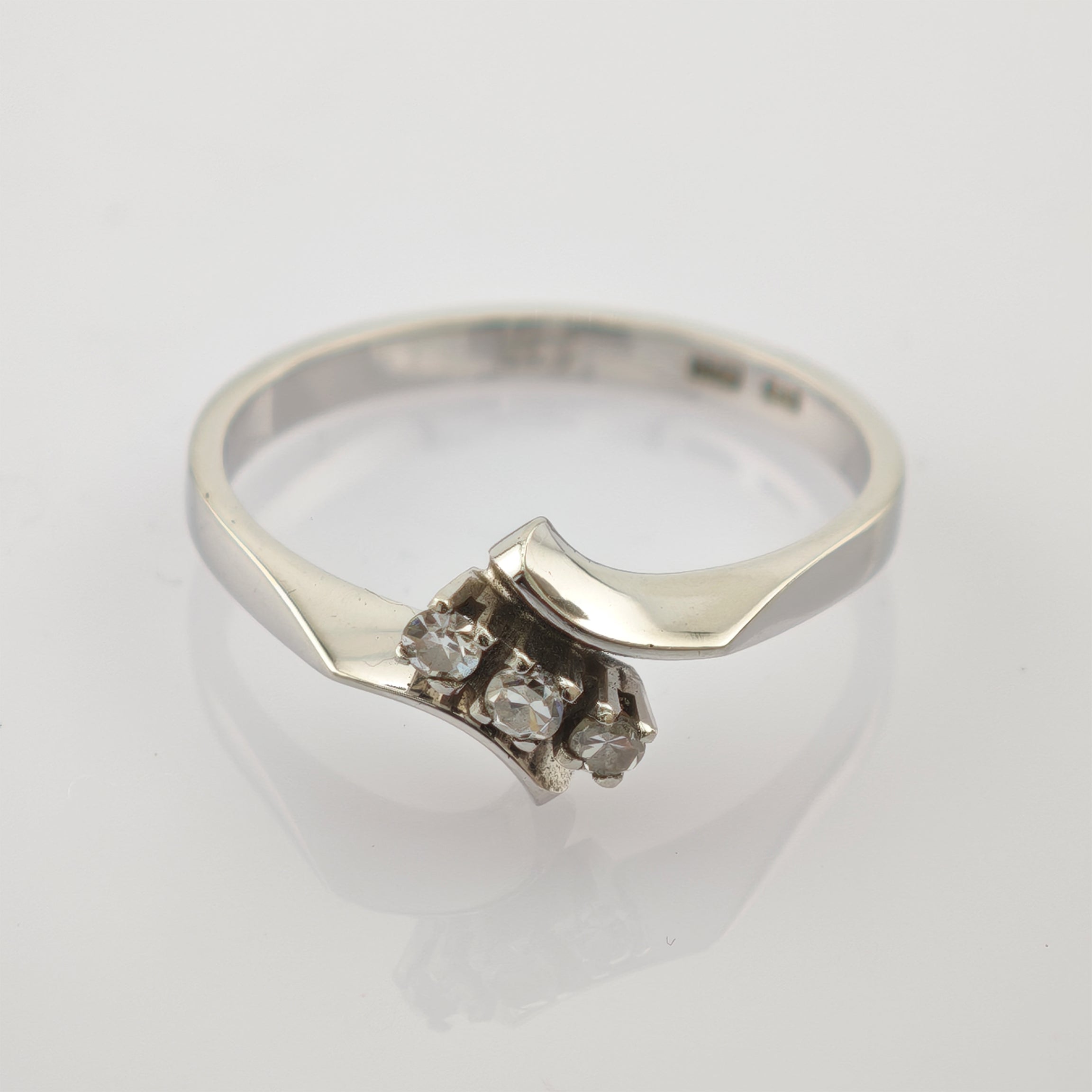 Silberner Ring aus 925 Sterling Silber mit modernem Design und drei kleinen klaren Steinen auf weißem Untergrund