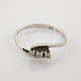 Eleganter silberner Ring mit gedrehter Bandschleife und drei kleinen runden Diamanten, innen mit 925 Sterling Punze.