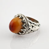 Silberner Ring mit blattverziertem Muster und ovalem Cabochon in Rot-Orange-Gradient.