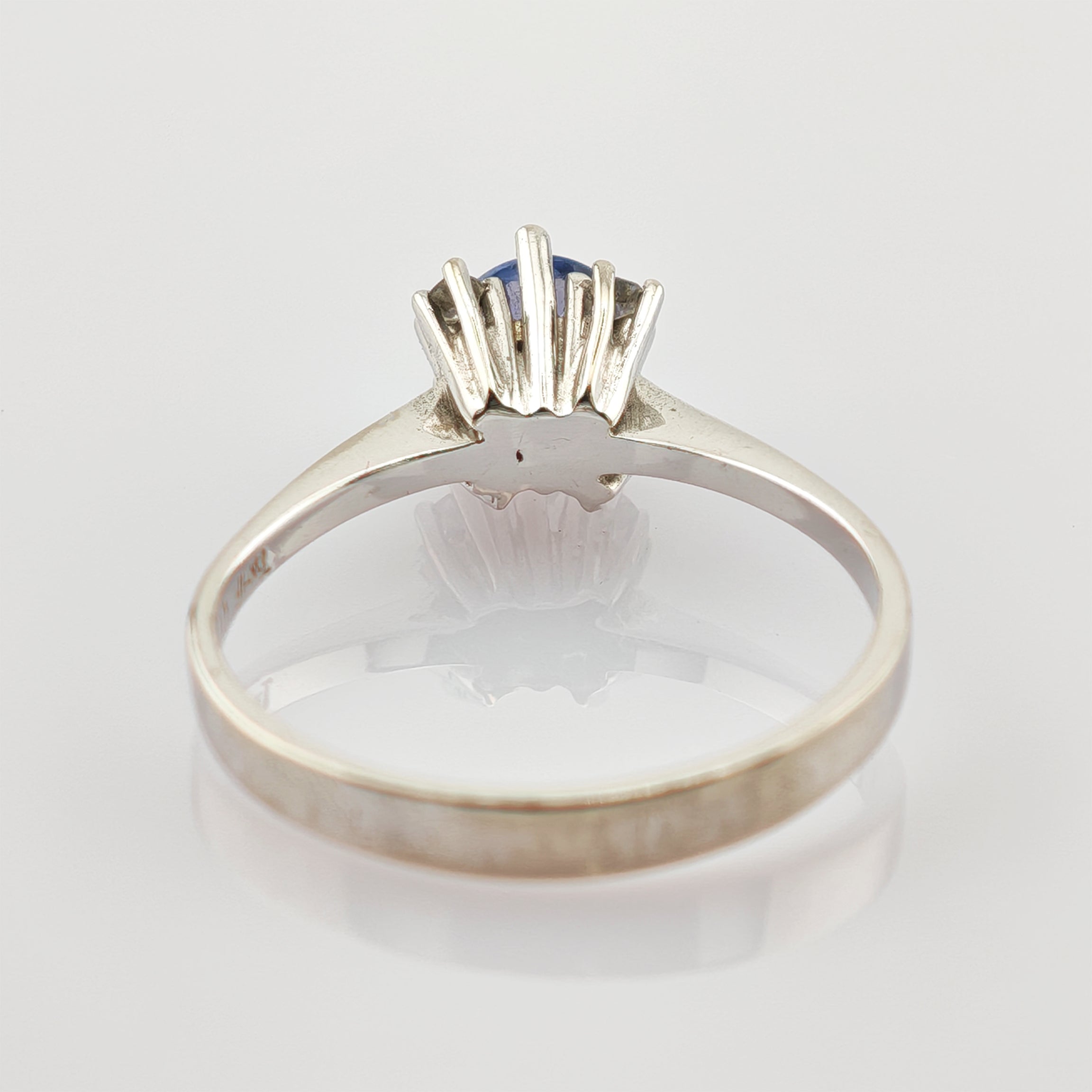 Silberner Ring mit blauem Edelstein in Krappenfassung und eingravierter 14K-Markierung auf dem Innenring.