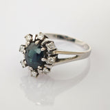 Silberring mit dunkelblauem Edelstein und Diamanten im Silberner Ring mit rundem dunkelblauem Stein und klaren Steinen im Blumencluster-Design mit geteiltem Schienenband.