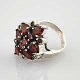 Silberner Ring mit blumenförmigem Arrangement aus tiefroten Rubinsteinen in Marquise- und Rundschliff