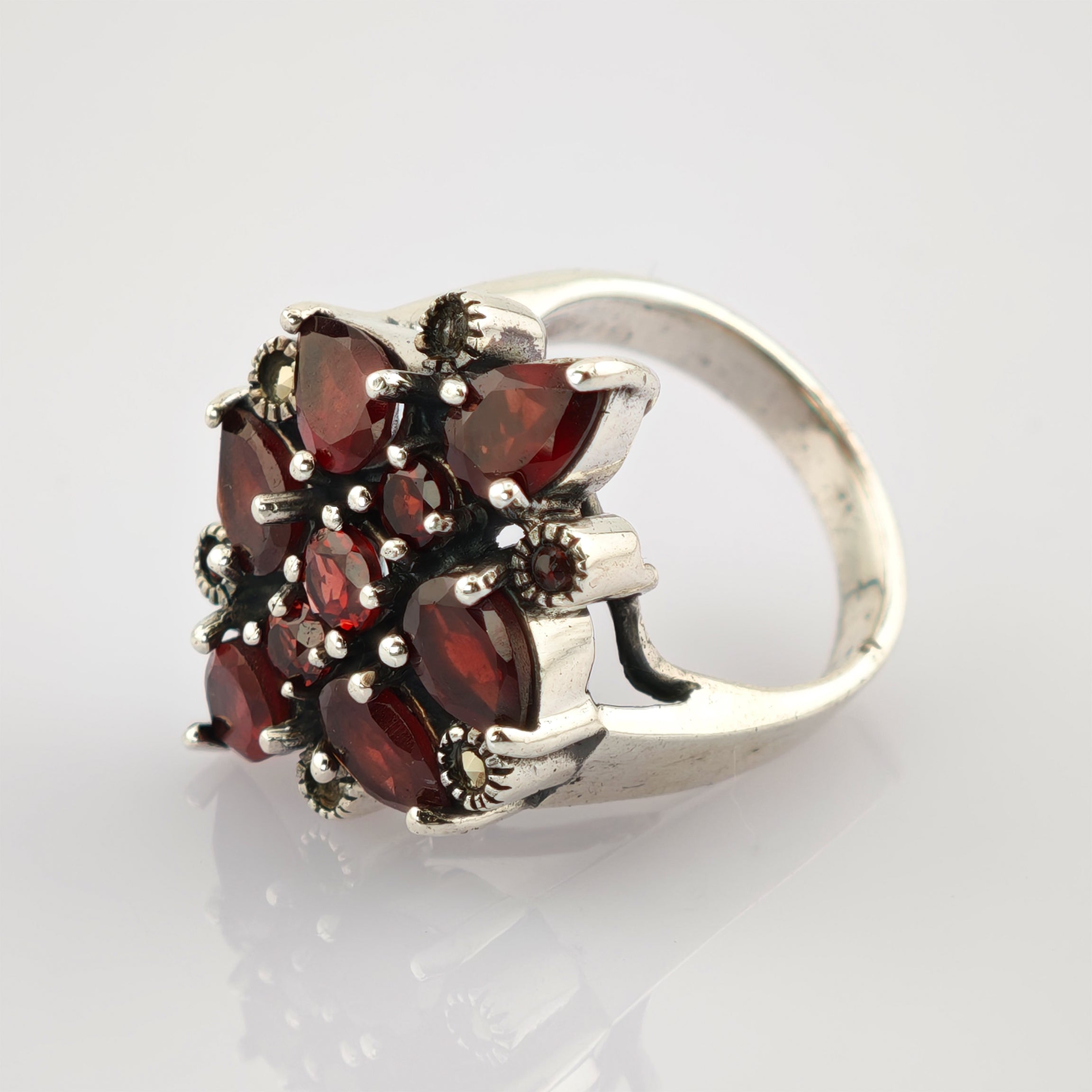 Silberner Ring mit blumenförmigem Arrangement aus tiefroten Rubinsteinen in Marquise- und Rundschliff