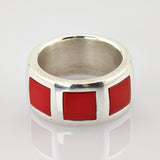 Silberner Ring mit breitem Band und drei quadratischen roten Emaille-Einlagen.