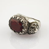 Silberner Ring mit facettiertem dunkelrotem Edelstein und viktorianischem Muster