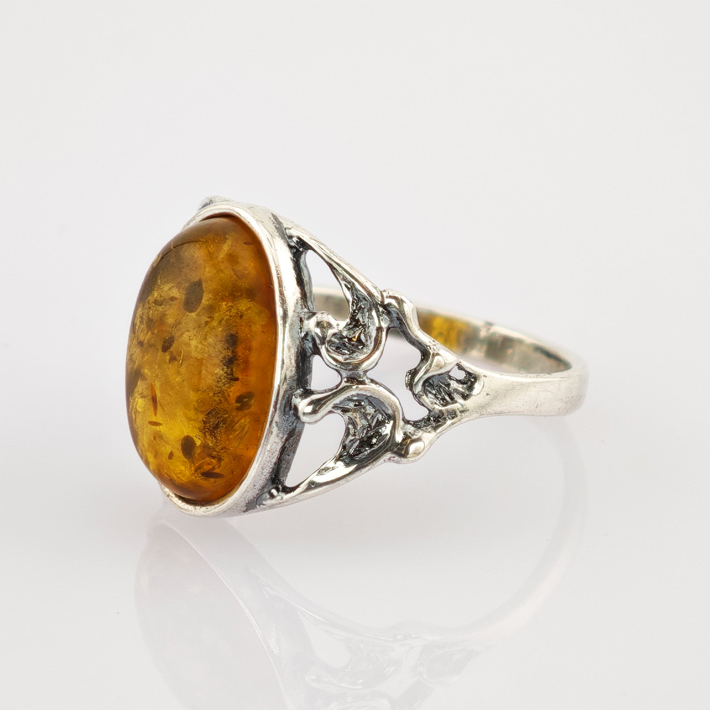 Silberner Ring mit filigranem Schnittmuster und großem ovalem Bernstein mit natürlichen Einschlüssen