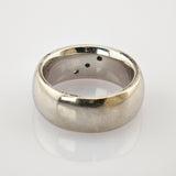 Silberner Ring mit glatter Außenseite und Löchern im inneren Band auf weißem Hintergrund