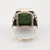 Silberner Ring mit quadratischem grünem Edelstein und texturierten Details am Ringband.