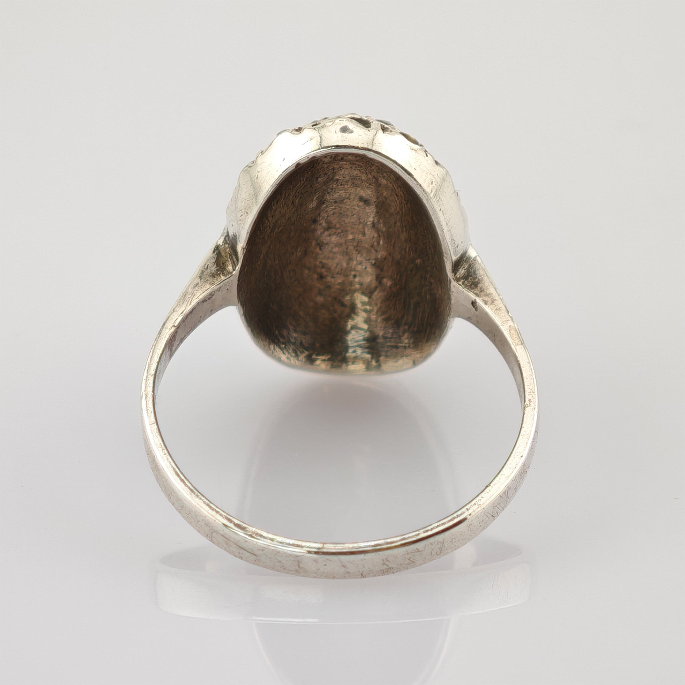 Silberner Ring mit hohlem, kuppelförmigem Innenbereich und reflektierender Oberfläche