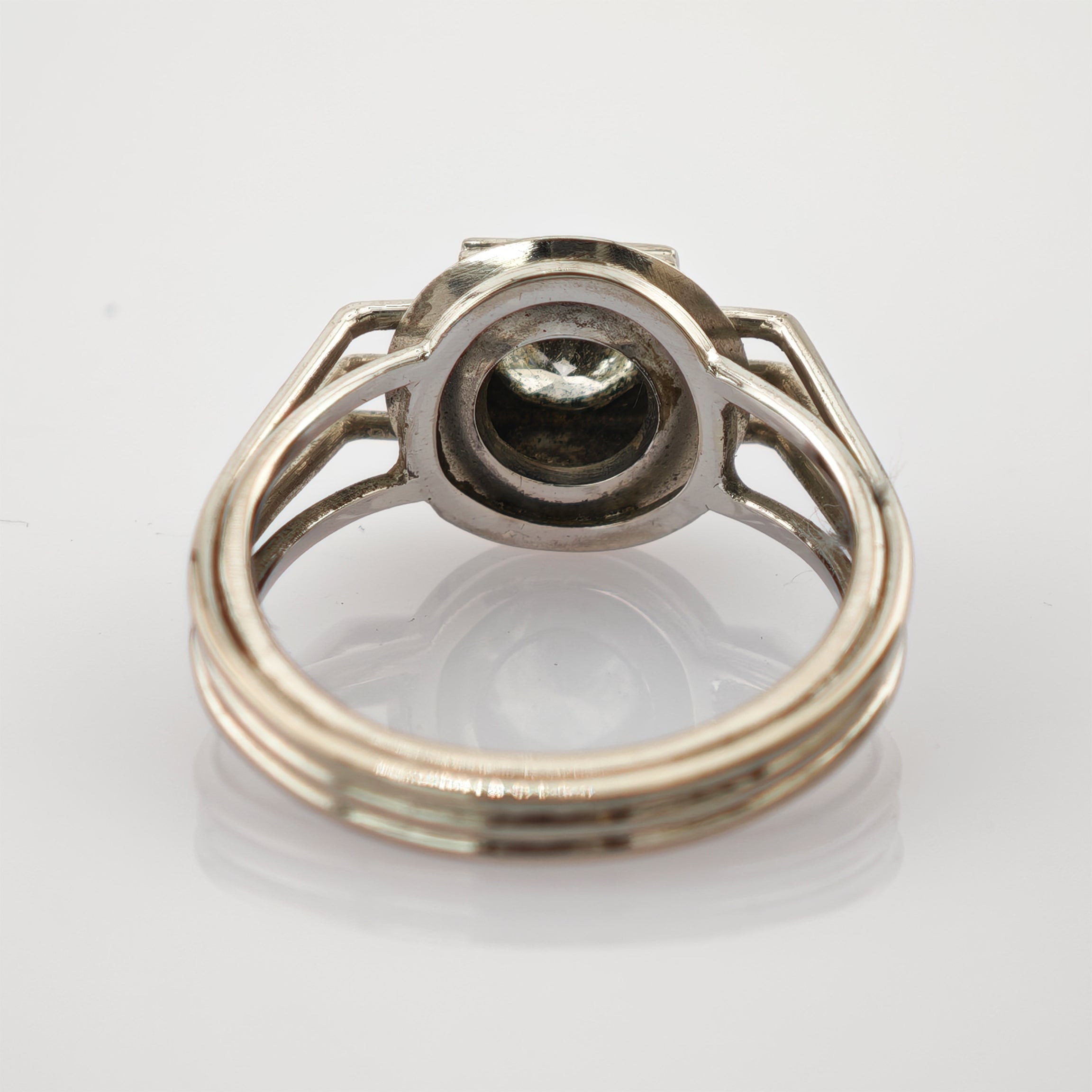 Nahaufnahme eines silbernen Rings mit hohlem Zentrum und poliertem Innenband vor weißem Hintergrund.