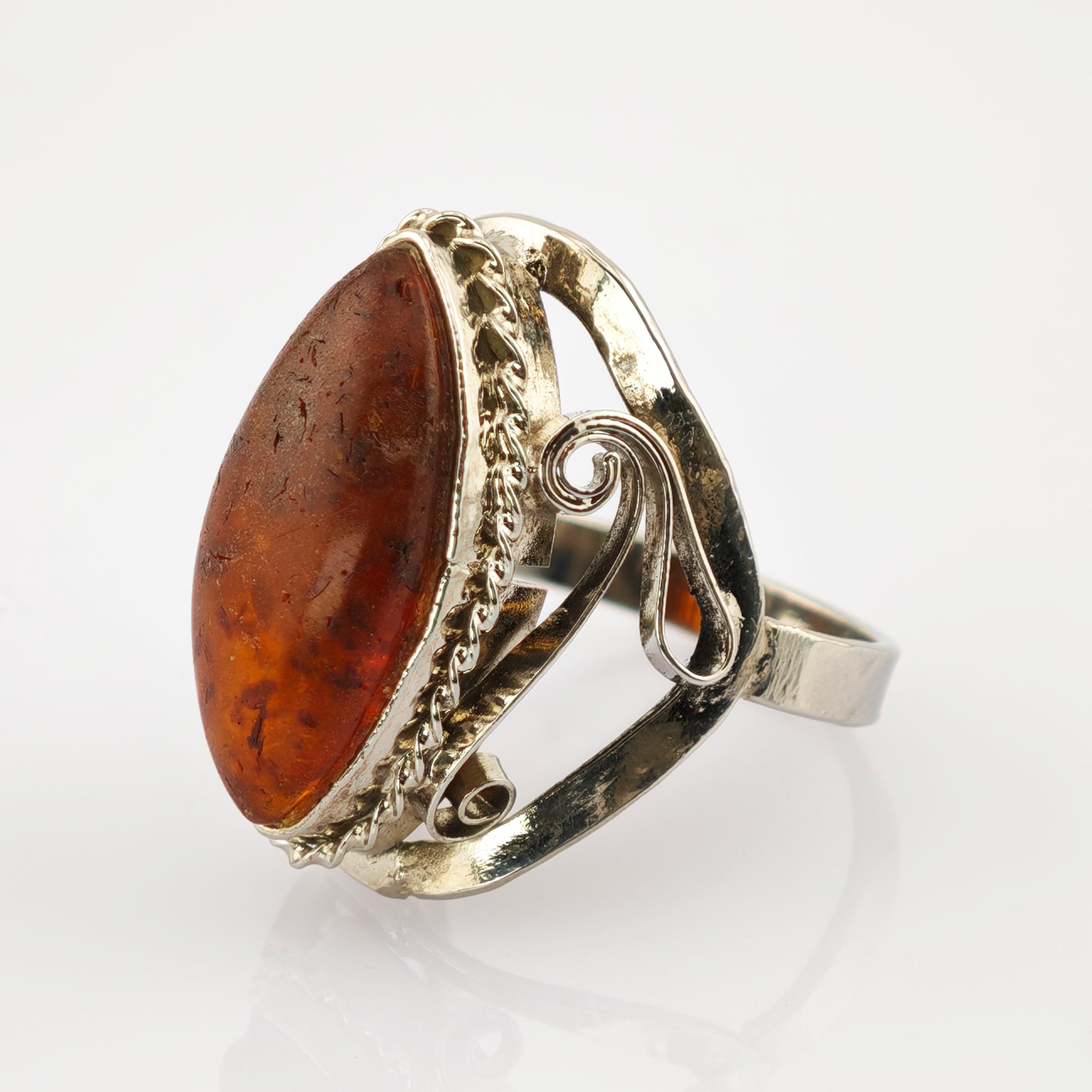 Silberner Ring mit ovalem Bernstein, umrahmt von verdrehtem Silberseil und dekorativem Schnörkelband