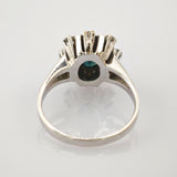 Nahaufnahme eines silbernen Rings mit ovalem blauem Edelstein und Krappenfassung