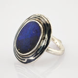 Eleganter silberner Ring mit ovalem blauem Stein und schwarzem Randmuster