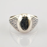 Silberner Ring mit ovalem schwarzen Mittelstück und weißen Blumenmustern in Dreiecksform