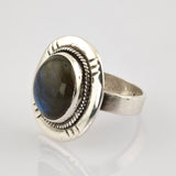 Silberner Ring mit großem ovalem dunklem Edelstein und verzierter Seilrandfassung mit dreieckigen Gravuren