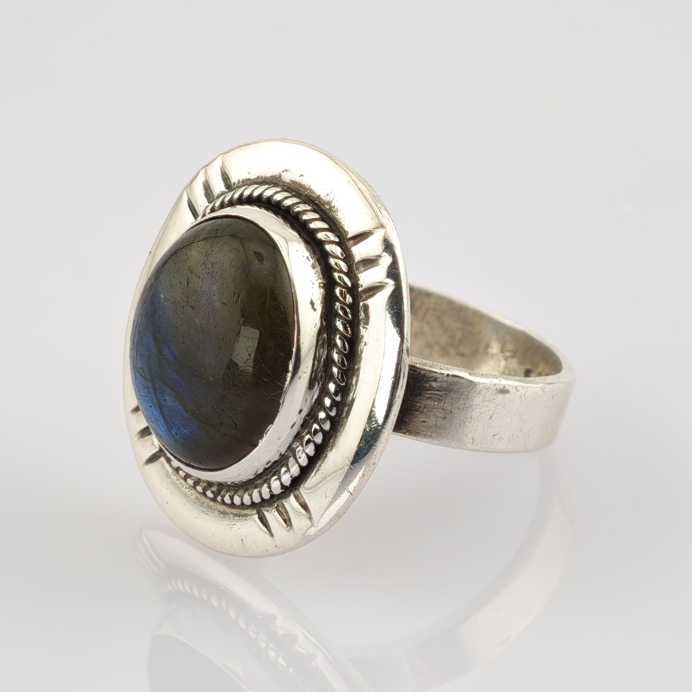 Silberner Ring mit großem ovalem dunklem Edelstein und verzierter Seilrandfassung mit dreieckigen Gravuren