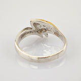 Nahaufnahme eines silbernen Rings mit oxidierter Innenseite und gelblicher, eingekerbter Oberseite auf weißem Hintergrund.