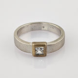 Silberner Ring mit quadratischer Fassung und klar geschliffenem Edelstein.