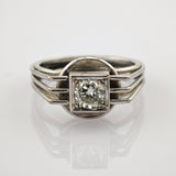 Silberner Ring mit großem rund geschliffenem Diamanten in quadratischer Fassung und dreiteiligem Band.