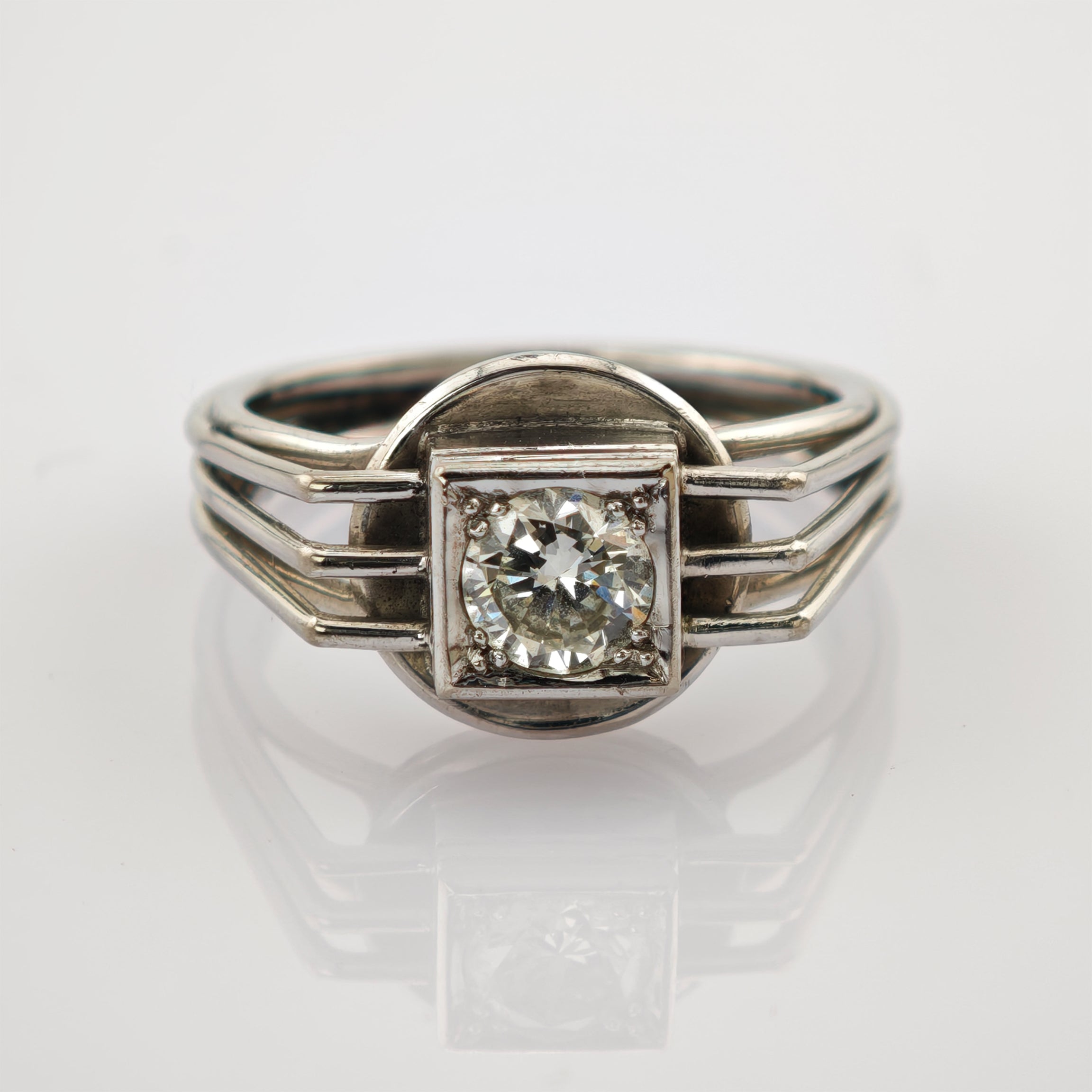 Silberner Ring mit großem rund geschliffenem Diamanten in quadratischer Fassung und dreiteiligem Band.