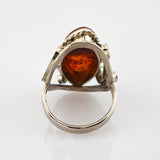 Silberner Ring mit tropfenförmigem Bernstein und kunstvoller Silberfassung, Vorderansicht