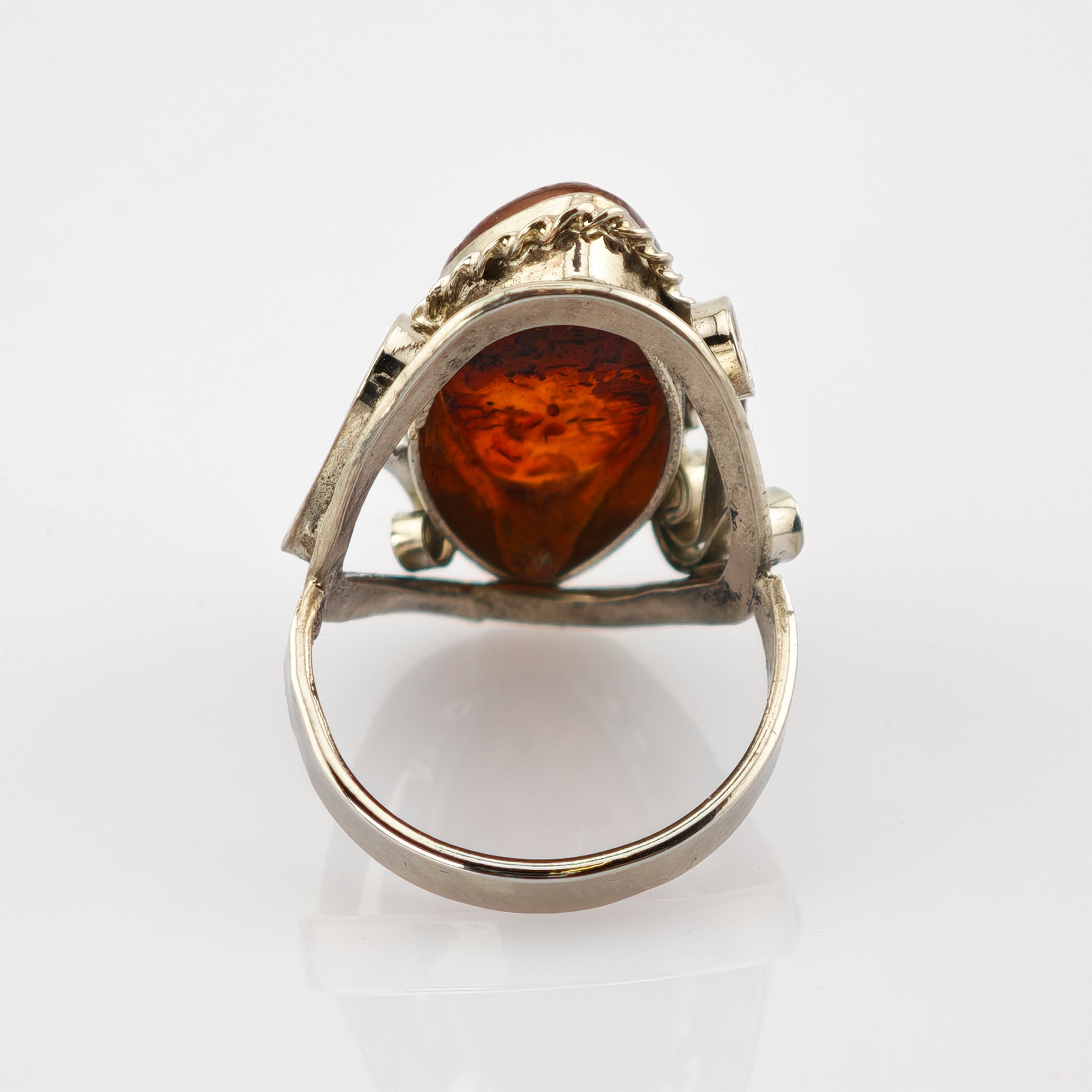 Silberner Ring mit tropfenförmigem Bernstein und kunstvoller Silberfassung, Vorderansicht