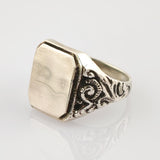 Silberner Siegelring mit oktogonalem flachen Gesicht und Gravuren auf weißem Hintergrund