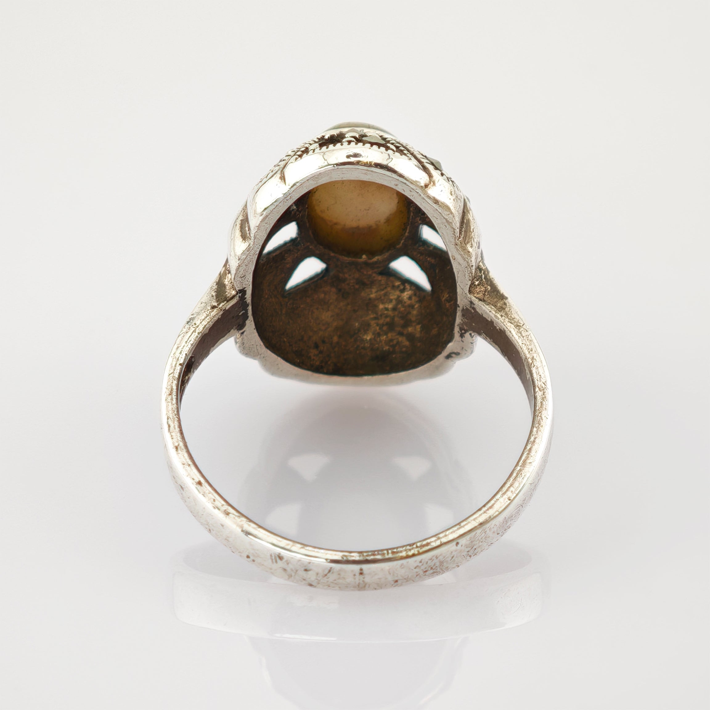 Silberner Vintage-Ring mit detaillierten Verzierungen und glänzendem Gehäuse aus Metall.