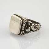 Silberner Vintage-Ring mit kunstvollen, gewundenen Details und rechteckiger, flacher Platine.